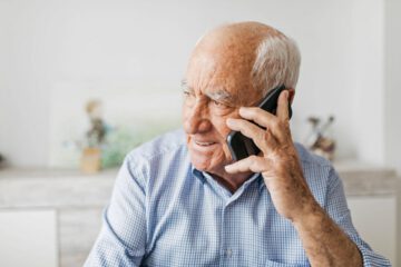 Foto zeigt älteren Mann beim telefonieren.