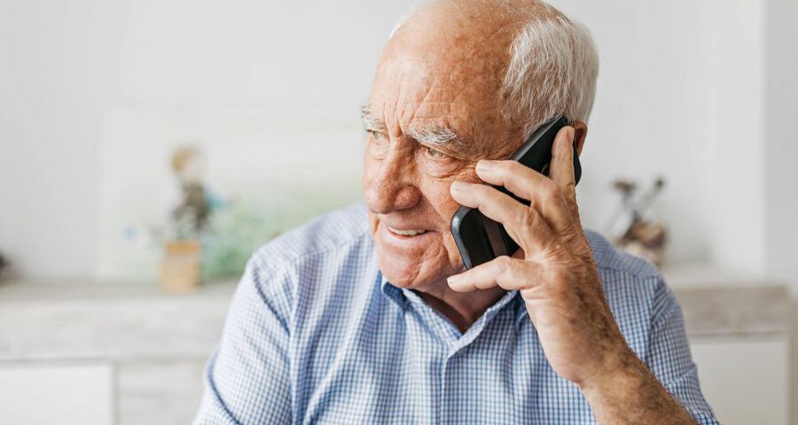 Foto zeigt älteren Mann beim telefonieren.